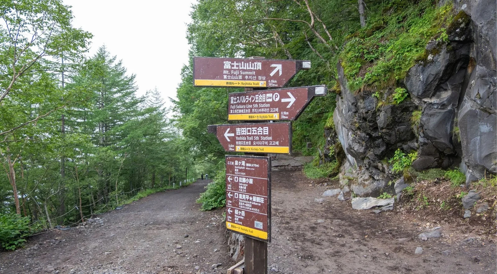 Multilingual trail signposts near the Fuji Subaru Line 5th Station pointing to the Mt. Fuji summit