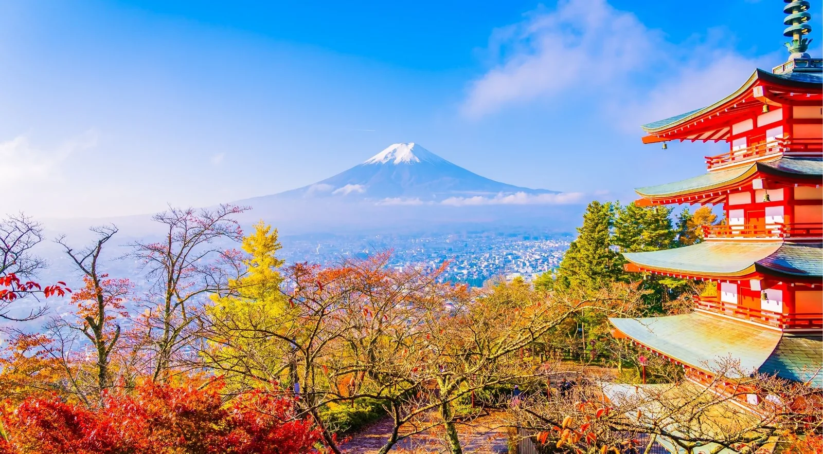 Chureito Pagoda on a hazy morning with golden ginkgo leaves and Mount Fuji beyond